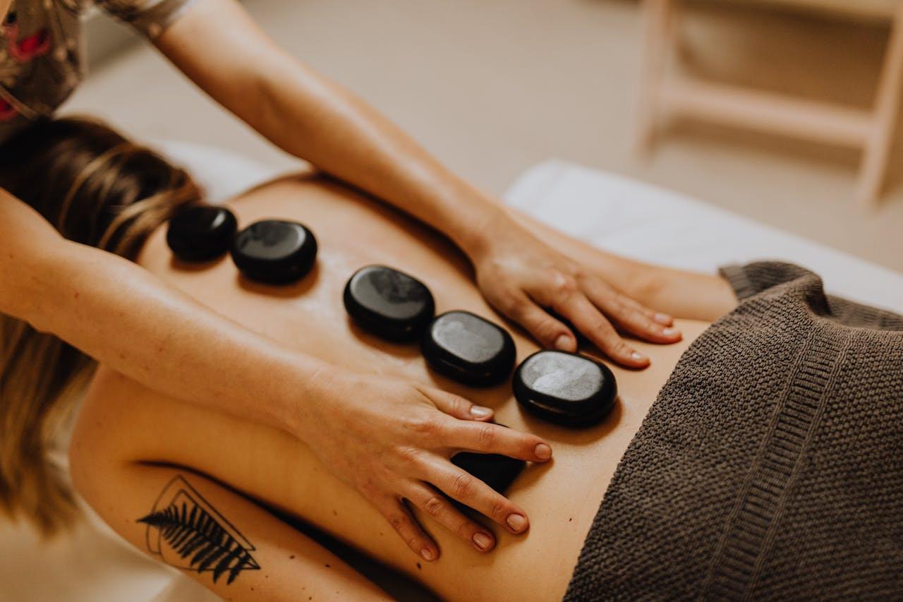 Hot stones layered along the back during a targeted hot stone back massage in Beck Row, Suffolk.